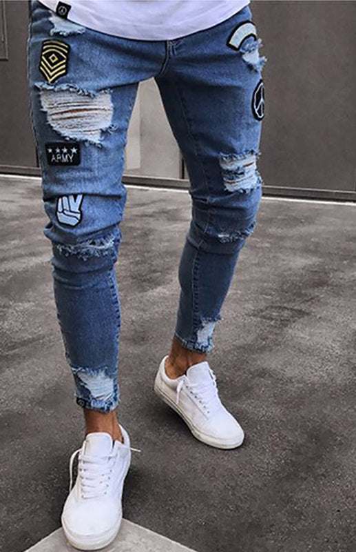 Men's distressed patchwork knit denim jeans with frayed details and patches.