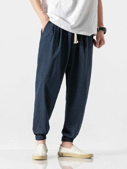 Men's woven linen casual harem trousers with mid waist and slant pockets, suitable for spring-summer.