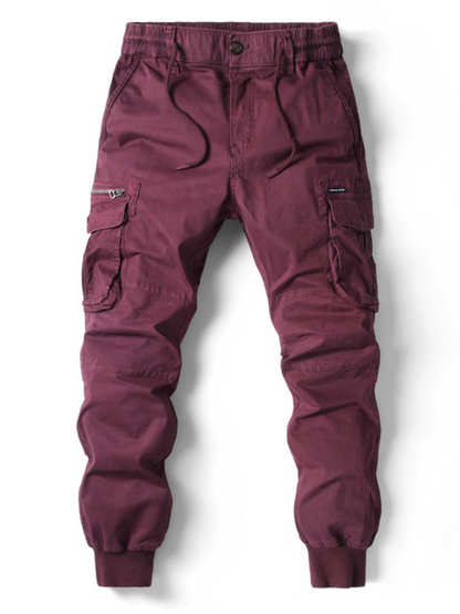 Men's casual solid color cargo pants in burgundy with welt pockets.